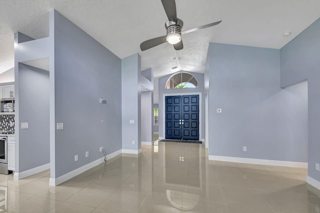 tiled foyer entrance featuring lofted ceiling, a textured ceiling, and ceiling fan