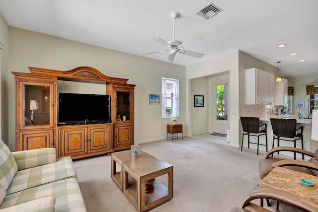 living room featuring light colored carpet and ceiling fan