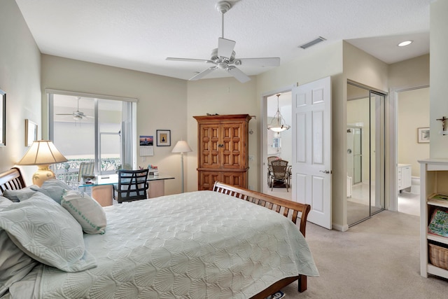 bedroom with a textured ceiling, a closet, light colored carpet, and ceiling fan