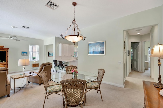 dining room with light colored carpet and ceiling fan