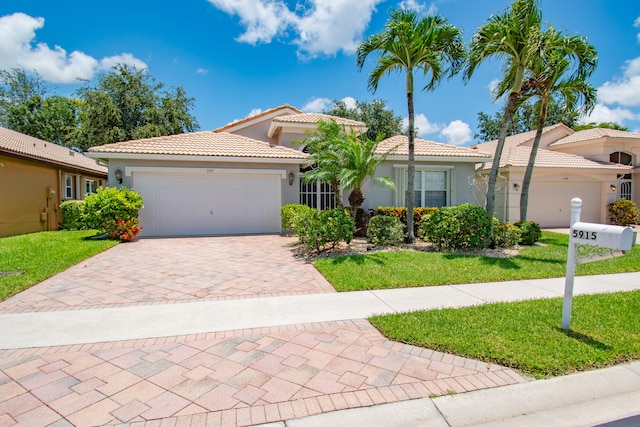 mediterranean / spanish house with a garage and a front yard