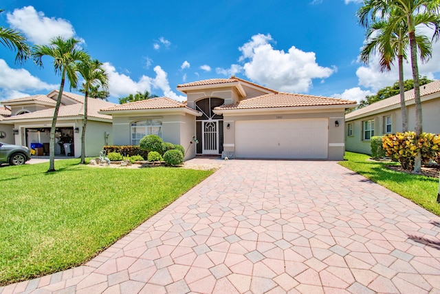 mediterranean / spanish-style house with a front yard and a garage