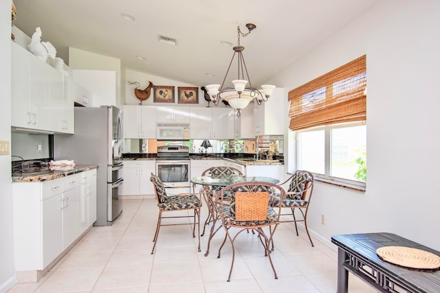 dining area featuring lofted ceiling, an inviting chandelier, light tile flooring, and sink