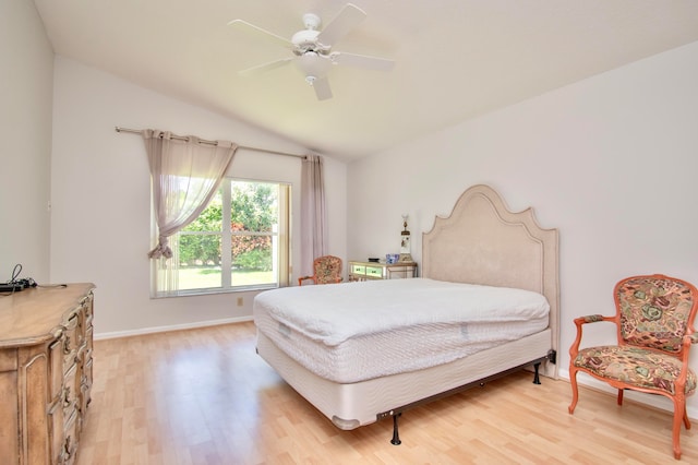 bedroom with ceiling fan, vaulted ceiling, and wood-type flooring