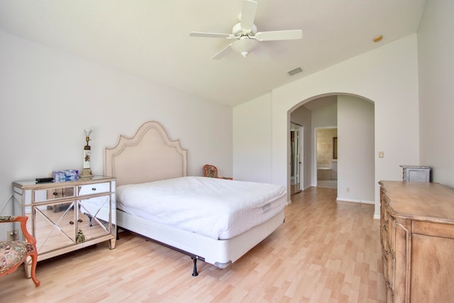 bedroom with ceiling fan, ensuite bath, and hardwood / wood-style floors