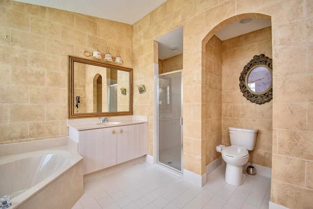 full bathroom featuring tile flooring, vanity with extensive cabinet space, tile walls, plus walk in shower, and toilet