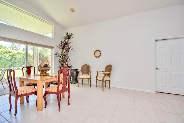 dining area featuring high vaulted ceiling and light tile flooring