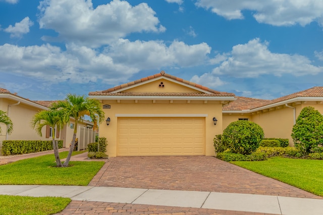 mediterranean / spanish house featuring a garage and a front lawn