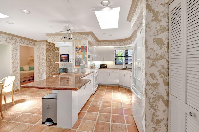 kitchen featuring white appliances, kitchen peninsula, stone countertops, white cabinetry, and a breakfast bar area