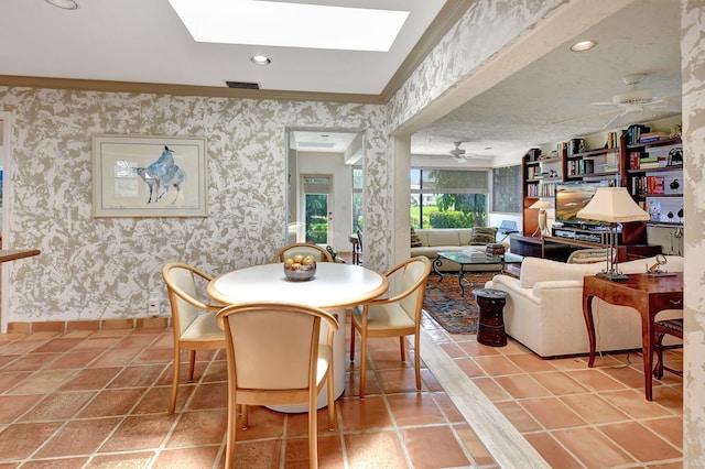 tiled dining area with a skylight and ceiling fan