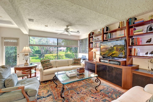 tiled living room with ceiling fan and a textured ceiling