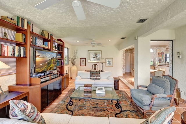 tiled living room featuring ceiling fan and a textured ceiling