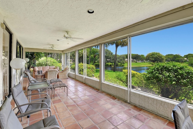 unfurnished sunroom with a water view and ceiling fan