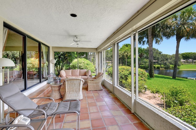 sunroom / solarium featuring ceiling fan and a water view