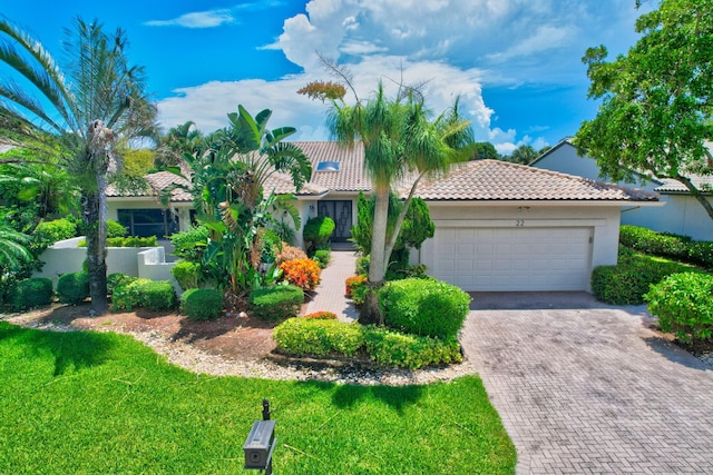 mediterranean / spanish-style home with a garage and a front yard