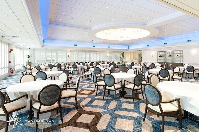 dining area with a raised ceiling and ornamental molding