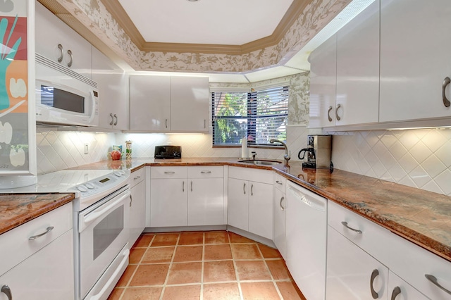 kitchen with white cabinetry, sink, light stone countertops, backsplash, and white appliances