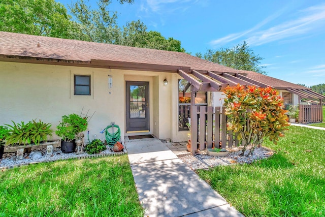 doorway to property with stucco siding, fence, and a shingled roof