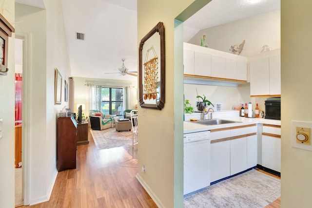 kitchen featuring white cabinets, white dishwasher, light hardwood / wood-style flooring, and sink