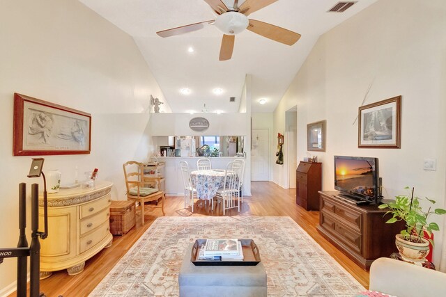 living room with light hardwood / wood-style floors, lofted ceiling, and ceiling fan