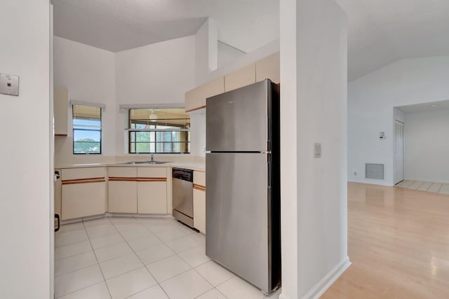 kitchen featuring visible vents, a sink, stainless steel appliances, light countertops, and cream cabinetry