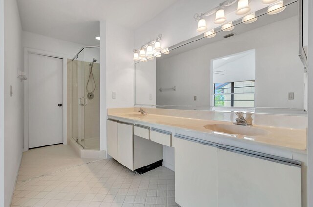 bathroom featuring tile flooring, an enclosed shower, and double vanity