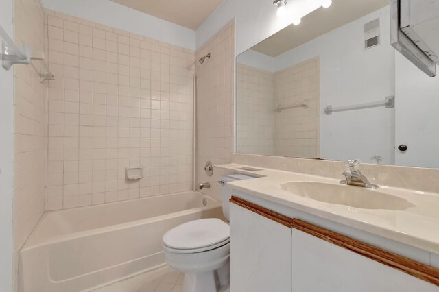 full bathroom featuring tile flooring, vanity, toilet, and tiled shower / bath