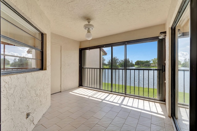 unfurnished sunroom featuring a water view and a wealth of natural light