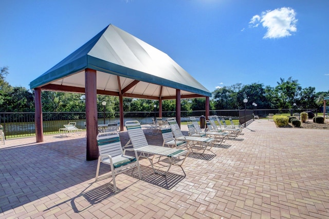 view of patio / terrace with a gazebo, a swimming pool, and fence