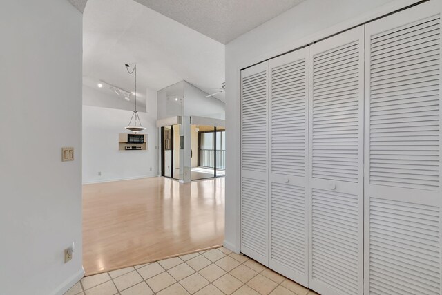 hallway with light hardwood / wood-style flooring and vaulted ceiling