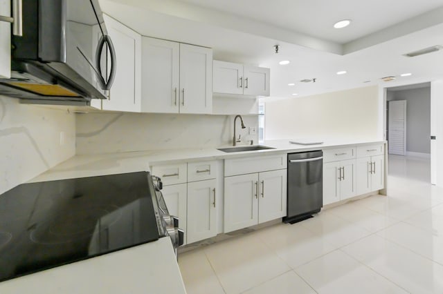 kitchen with stove, sink, light tile patterned floors, dishwasher, and white cabinetry