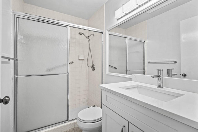 bathroom featuring vanity, an enclosed shower, and toilet