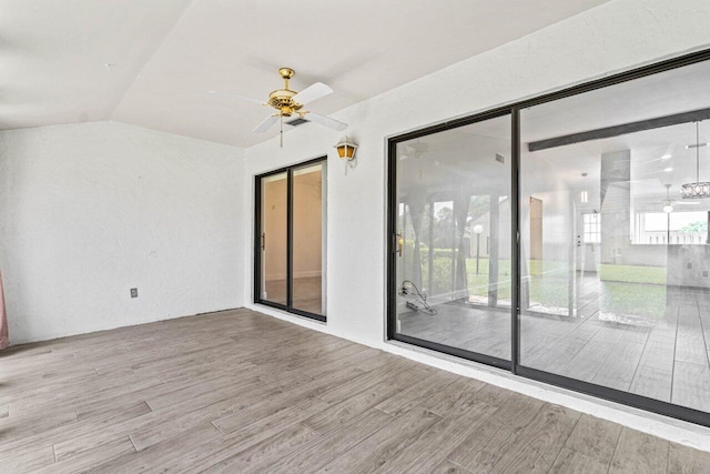 empty room with vaulted ceiling, light hardwood / wood-style flooring, and ceiling fan