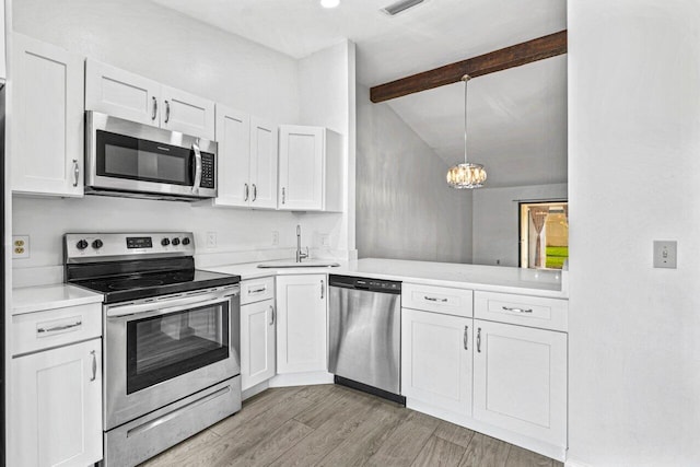 kitchen featuring stainless steel appliances, vaulted ceiling with beams, light hardwood / wood-style floors, decorative light fixtures, and white cabinets