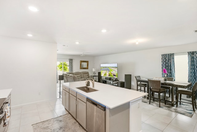 kitchen featuring light tile patterned floors, a center island with sink, stainless steel appliances, and sink