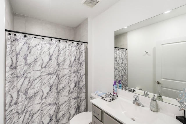 bathroom with curtained shower, vanity, and toilet