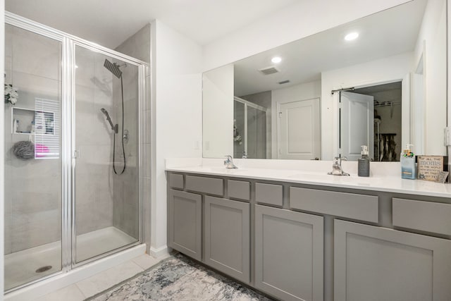 bathroom with vanity, an enclosed shower, and tile patterned floors