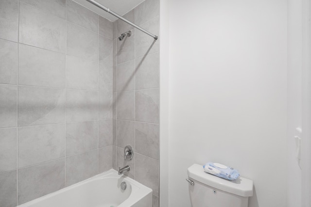 bathroom featuring toilet and tiled shower / bath