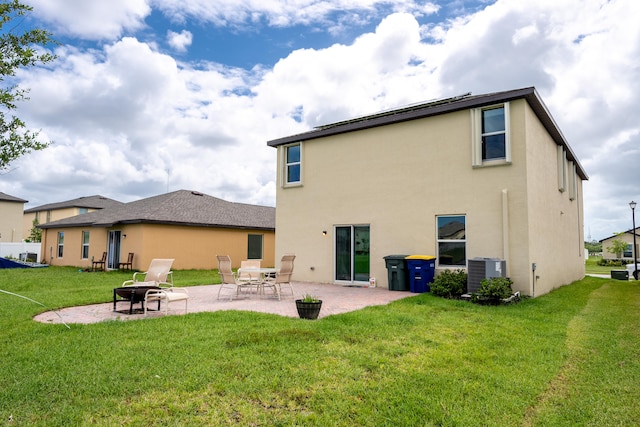 rear view of house with a yard, a patio, and central air condition unit