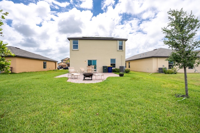 rear view of house featuring a lawn, central air condition unit, and a patio area