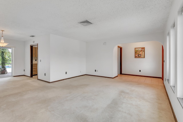 carpeted spare room featuring a textured ceiling