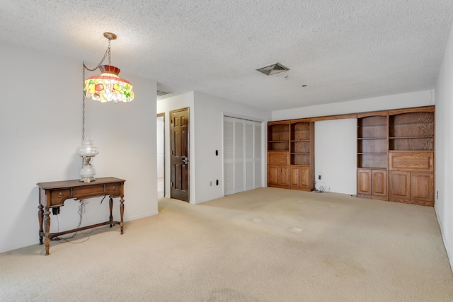 carpeted empty room with a textured ceiling