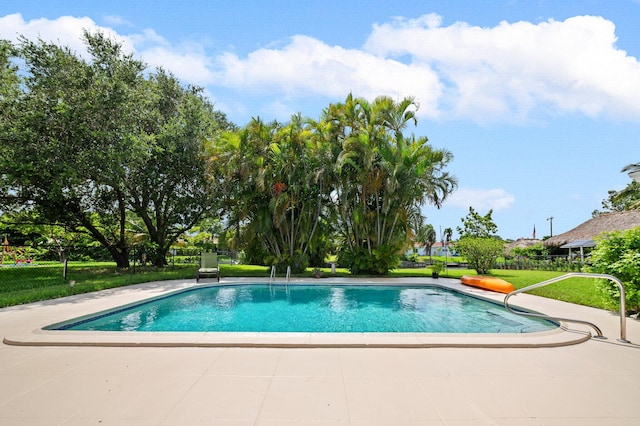 view of swimming pool featuring a lawn