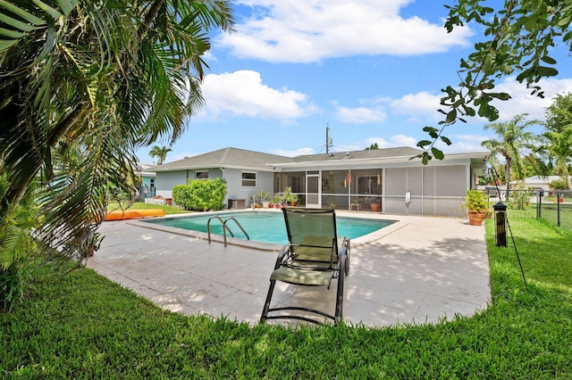 view of swimming pool with a sunroom, a yard, and a patio