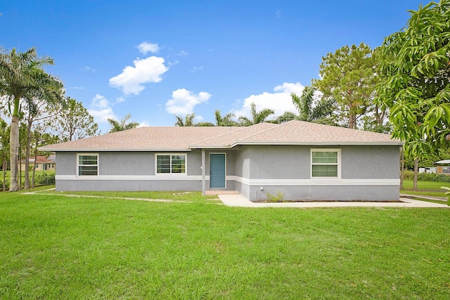 single story home with a shingled roof, a front yard, and stucco siding