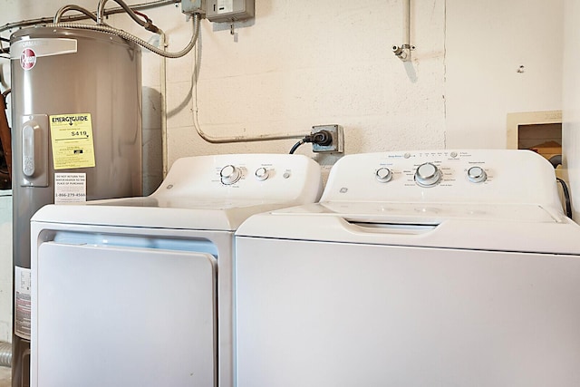 clothes washing area featuring electric water heater and washer and dryer