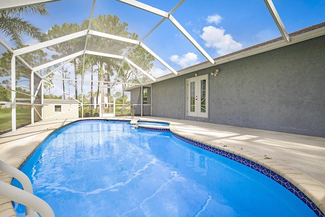 view of pool featuring an outbuilding, french doors, glass enclosure, and a patio