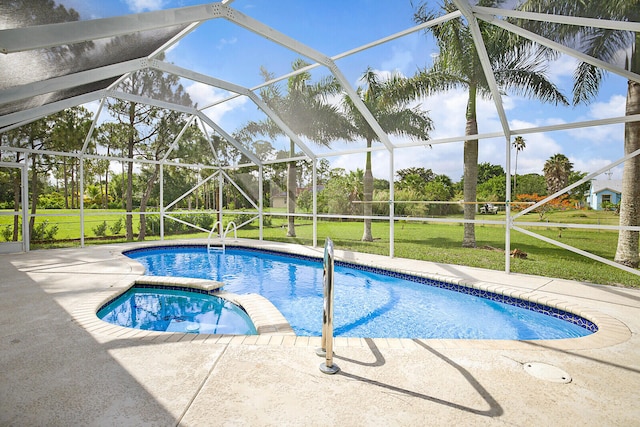 view of swimming pool featuring a lanai, a yard, a patio, and an in ground hot tub