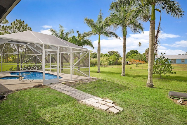 view of yard featuring glass enclosure and a pool with hot tub