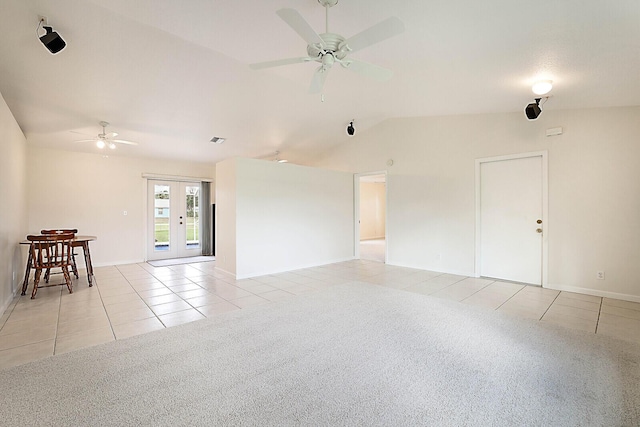 empty room with light tile patterned floors, ceiling fan, lofted ceiling, light carpet, and french doors